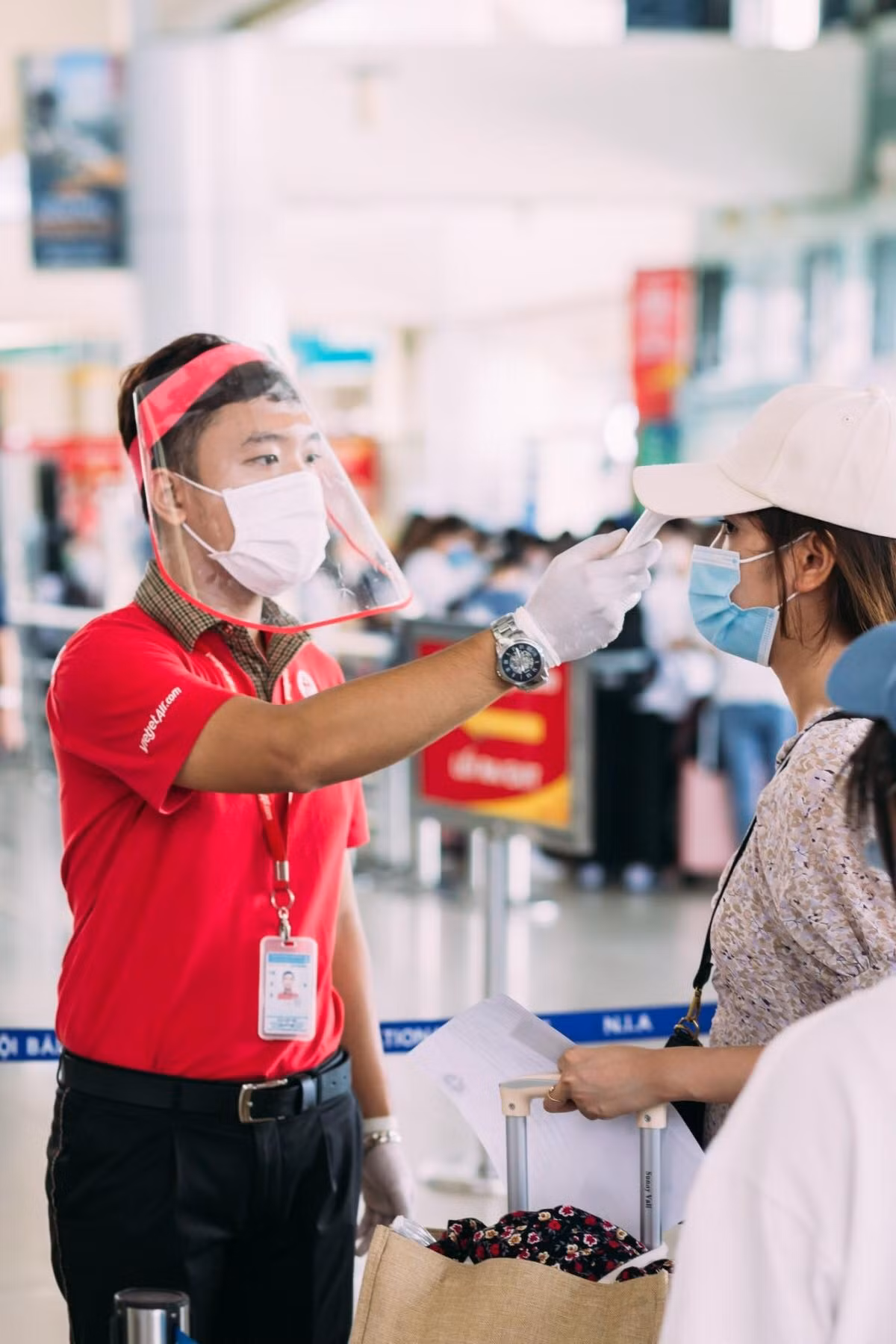 Kiểm tra thân nhiêt, phòng chống dịch COVID-19 cho khách đi máy bay.