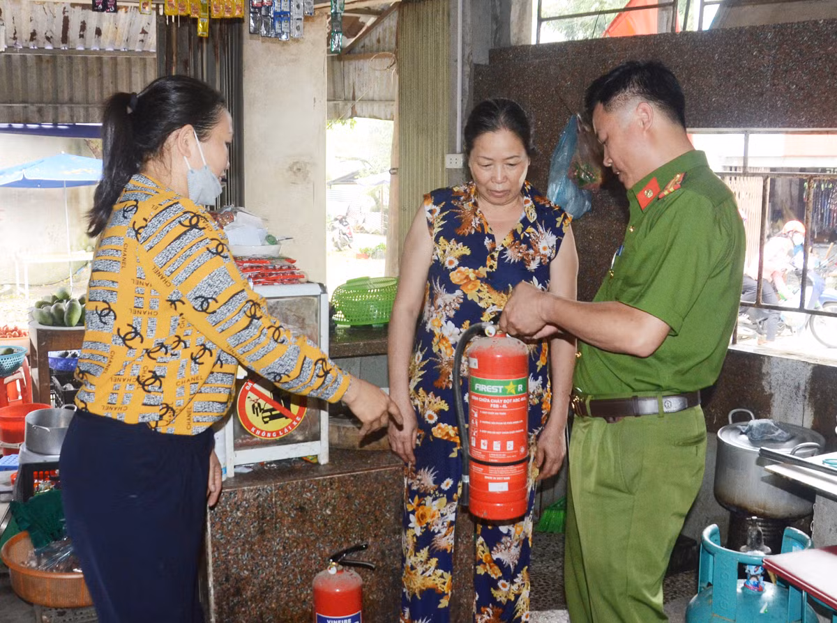 Công an thành phố và dân phòng cơ sở tuyên truyền cho hộ có nhà ở kết hợp kinh doanh trang bị bình phun chữa cháy.