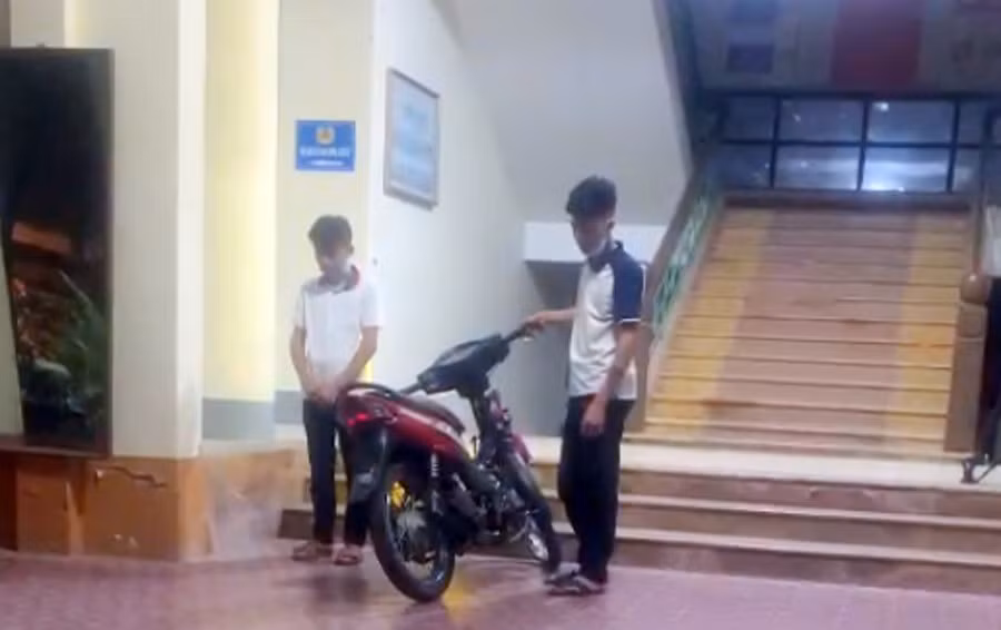 N.Đ.T.T (phía bên phải) cùng chiếc xe máy vi phạm tại cơ quan công an.