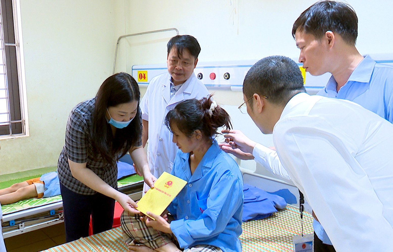Đồng chí Vũ Thị Hiền Hạnh - Phó Chủ tịch UBND tỉnh thăm hỏi và trao tiền hỗ trợ cho các gia đình nạn nhân đang điều trị tại Trung tâm Y tế khu vực Văn Yên. sequence-0100-03-21-19still005.jpg