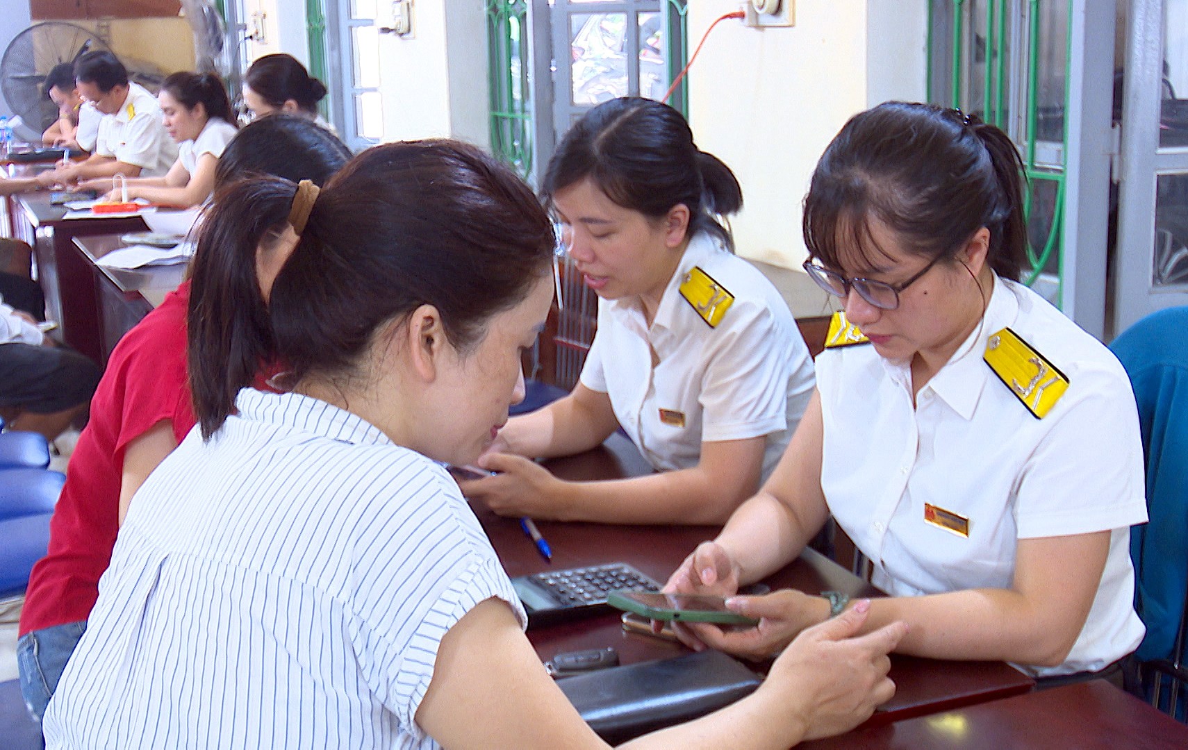 Cán bộ Tổ quản lý cá nhân kinh doanh số 2 hướng dẫn người dân cài đặt nộp thuế qua ứng dụng Etax Mobile. thue111.jpg