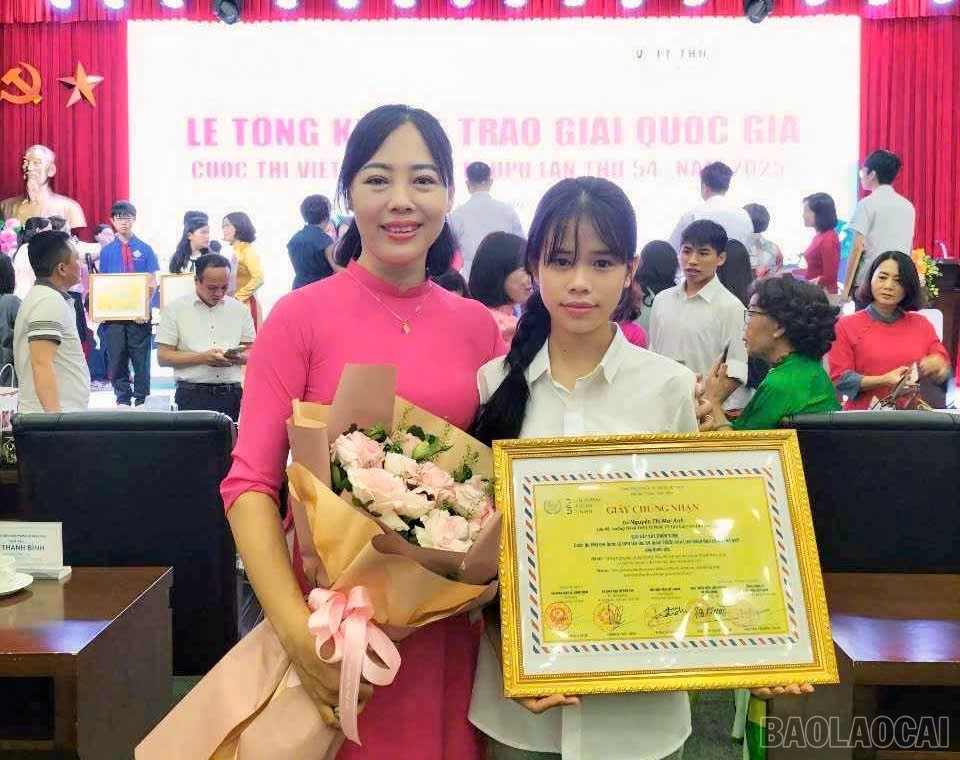 Em Nguyễn Thị Mai Anh, học sinh lớp 9B, Trường Tiểu học và THCS Tả Phời (thành phố Lào Cai) và cô giáo hướng dẫn tại lễ trao giải. baolaocai-br_z6609281401639-74a1918a5453bafe0998a5bdb745c821.jpg