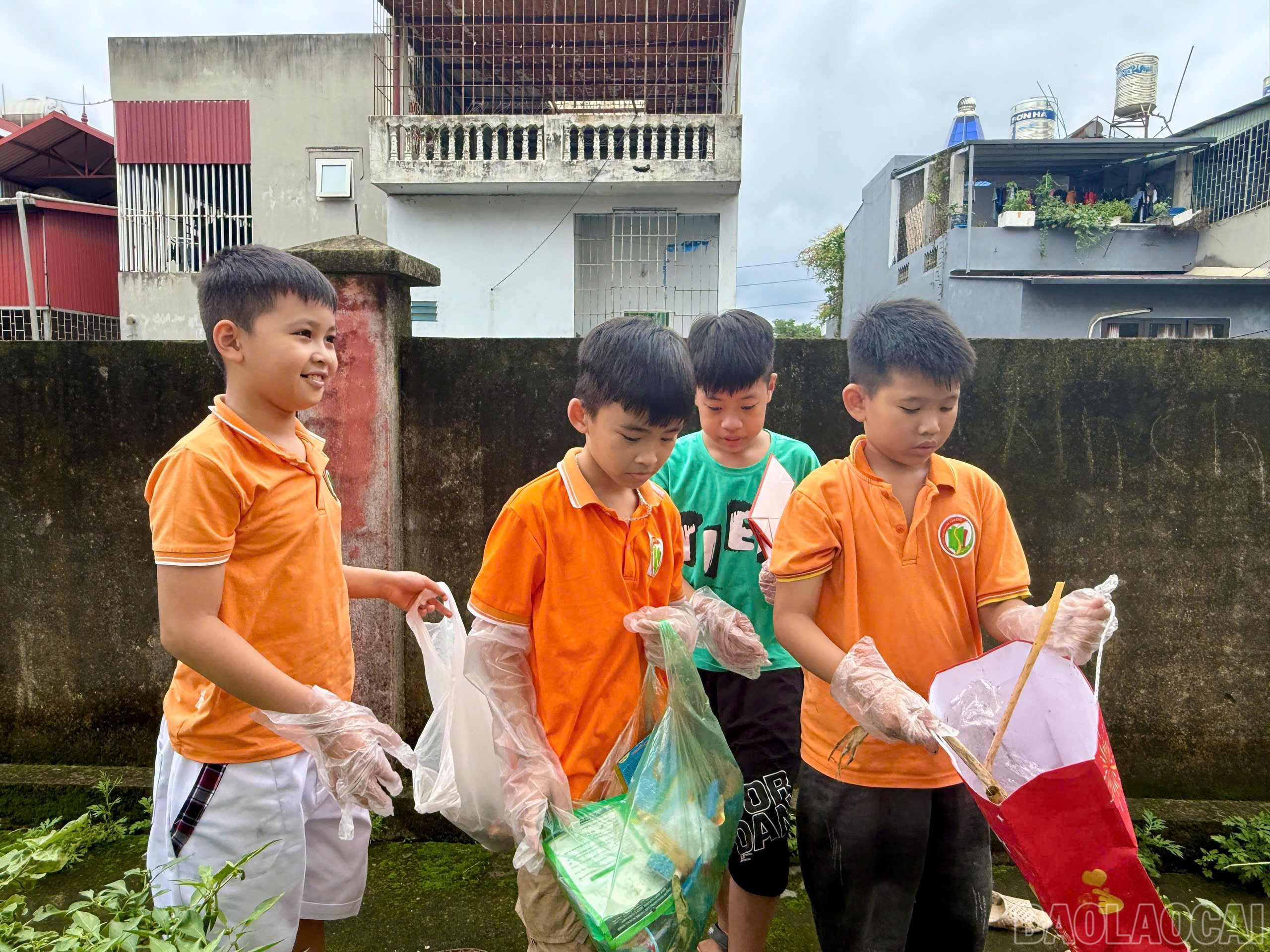 Các em học sinh thu gom rác bảo vệ môi trường. baolaocai-br_z6654574064447-a2a4a95331208302c57773671112cf1e.jpg