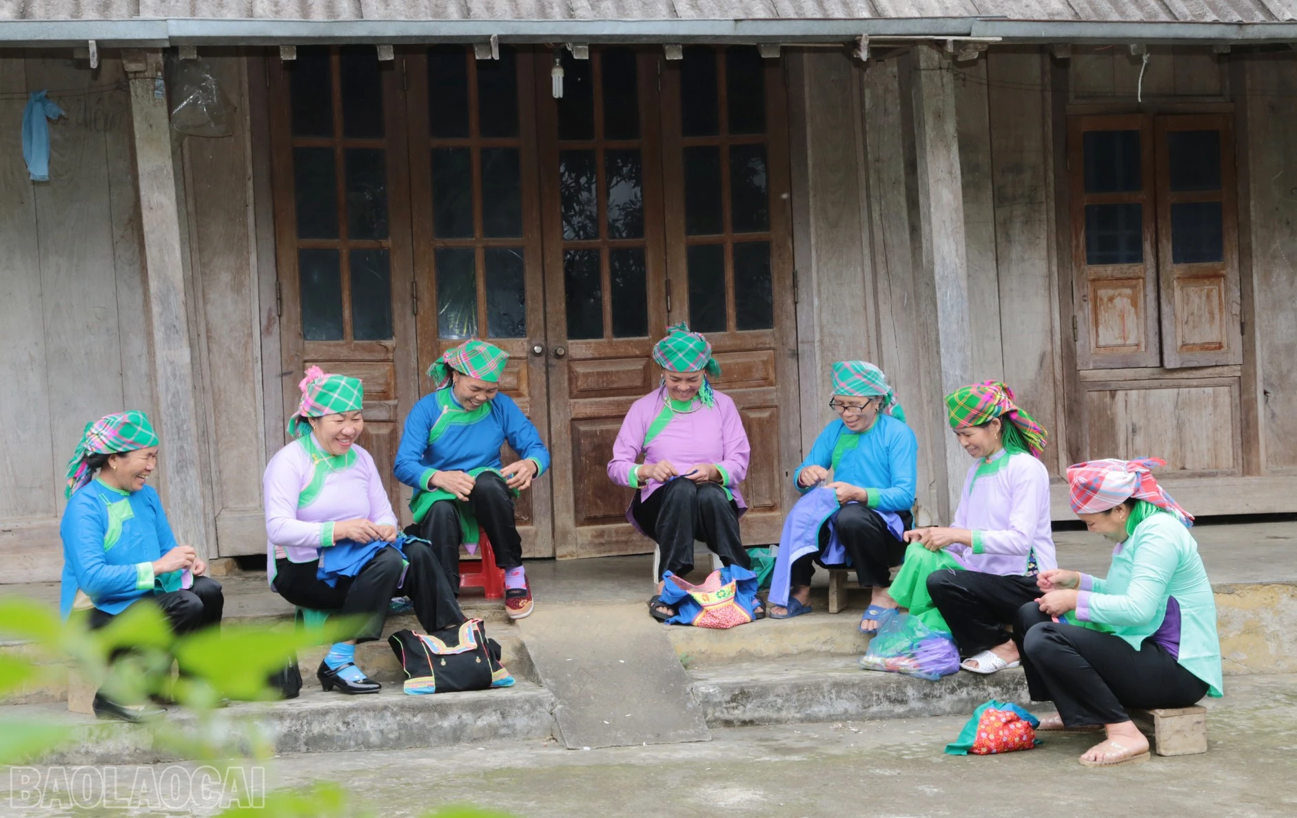 2.Chị em phụ nữ dân tộc Giáy ở thôn Lùng Vai, xã Lùng Vai cặm cụi may thêu áo bên hiên nhà..JPG