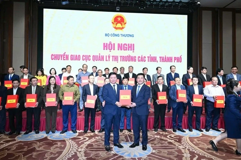 Bộ trưởng Nguyễn Hồng Diên trao biên bản bàn giao Cục Quản lý thị trường từ Bộ Công Thương về UBND các tỉnh, thành phố - Ảnh: VGP