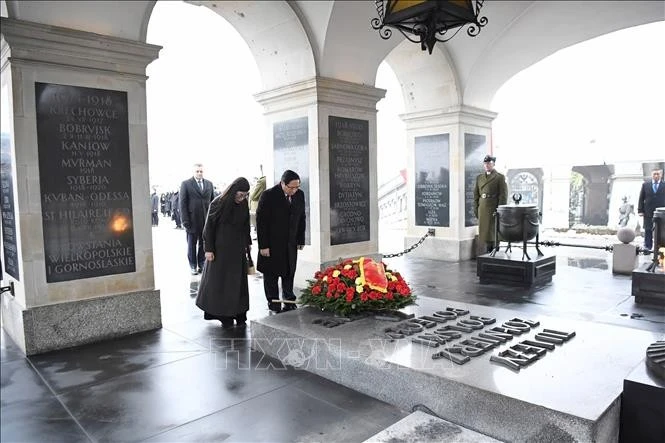 Thủ tướng Phạm Minh Chính và Phu nhân đặt vòng hoa tại Khu tưởng niệm các Liệt sĩ vô danh Ba Lan. Ảnh: Dương Giang/TTXVN