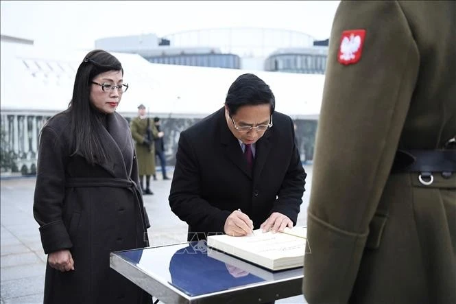 Thủ tướng Phạm Minh Chính và Phu nhân ghi lưu bút tại Khu tưởng niệm các Liệt sĩ vô danh Ba Lan. Ảnh: Dương Giang/TTXVN