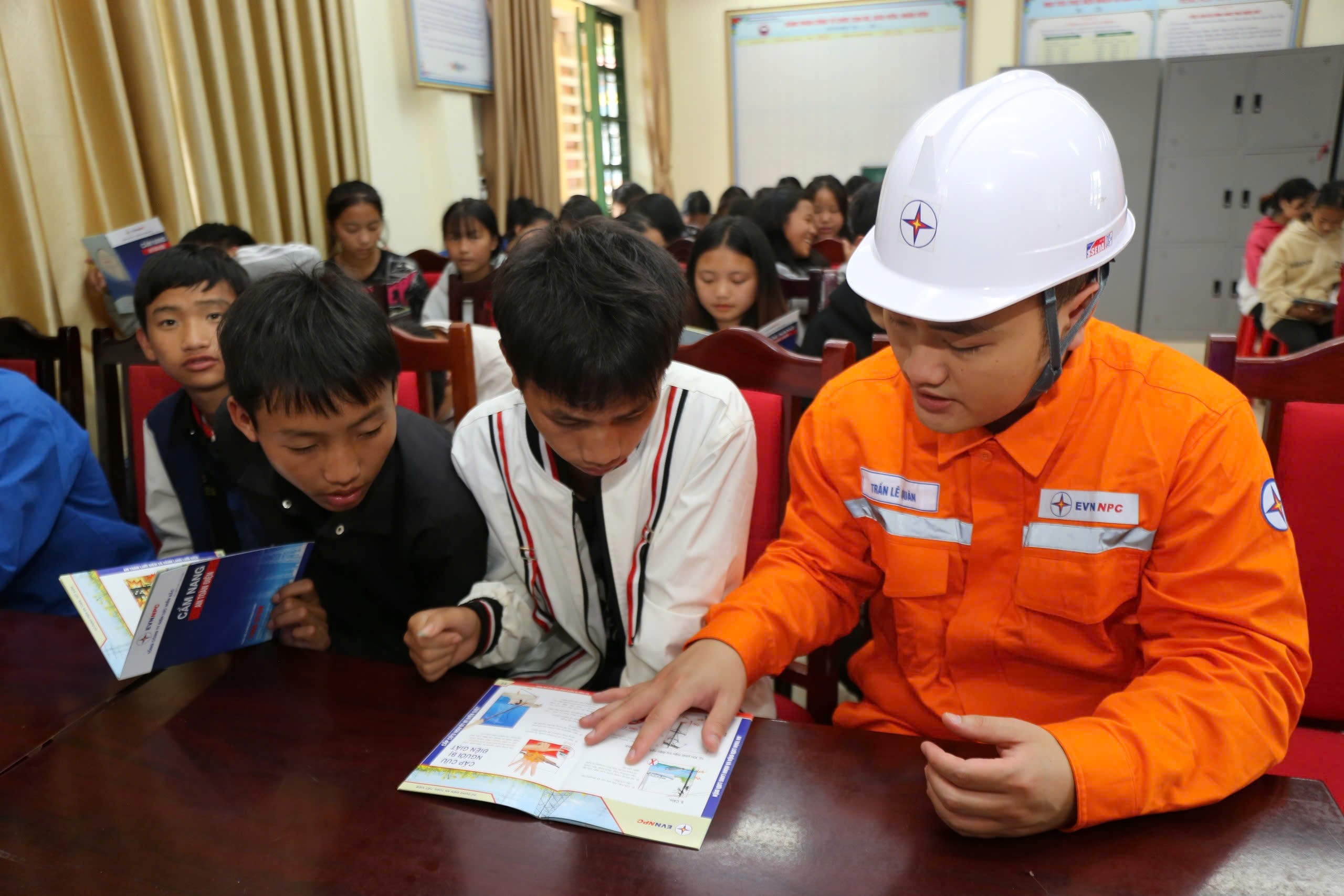 Công nhân Điện lực Bắc Hà hướng dẫn học sinh tìm hiểu các biện pháp an toàn thông qua cuốn cẩm nang an toàn điện. z6625623139960-d7a947df2d019dca5214d286f9b2fedf.jpg