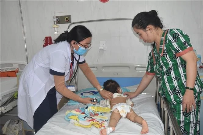 Bác sỹ thăm, khám cho bệnh nhi bị sởi phải thở oxy do biến chứng viêm phổi nặng. Ảnh: Nguyên Dung/TTXVN