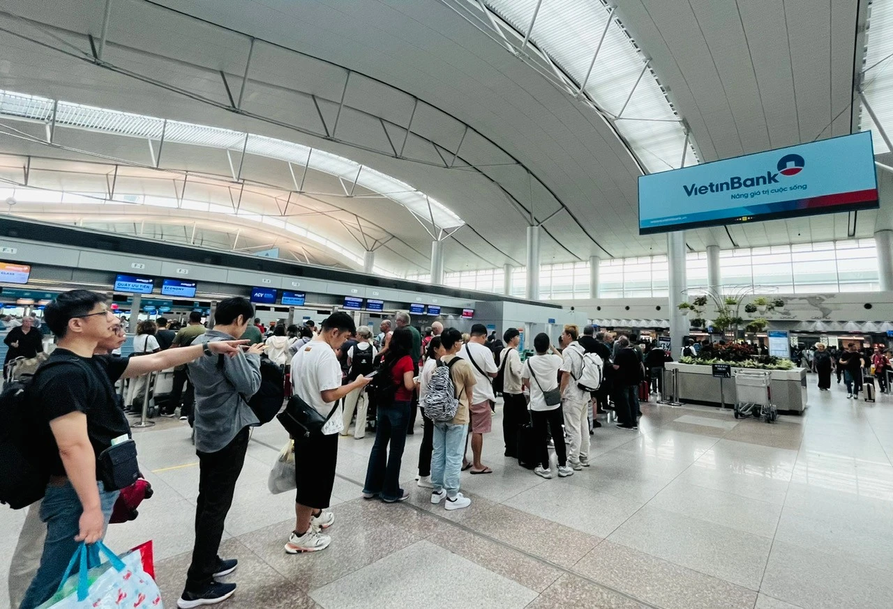 Người dân, du khách xếp hàng chờ làm thủ tục xuất cảnh tại sân bay Tân Sơn Nhất.