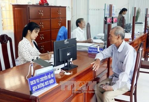 Người dân đến giao dịch tại Bộ phận tiếp nhận và trả kết quả một cửa liên thông hiện đại thành phố Vĩnh Long. Ảnh: TTXVN