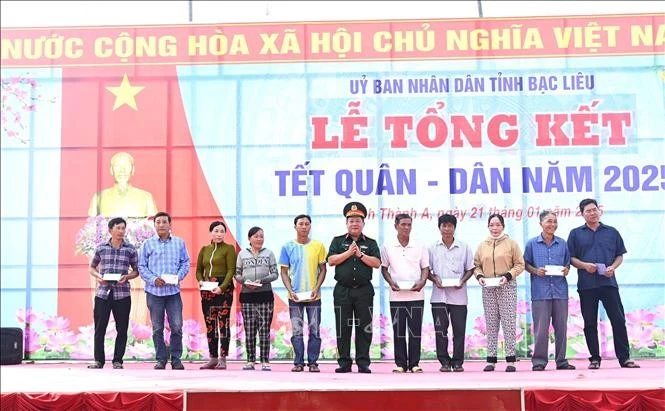 Đại tá Lê Hoàng Giữ, Phó Chủ nhiệm Chính trị Quân khu 9 tặng quà cho các gia đình có hoàn cảnh khó khăn tại buổi lễ Tết Quân - Dân. Ảnh: Chanh Đa/TTXVN