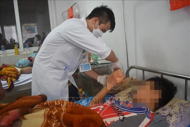 Bác sỹ thăm khám cho em P.C.H bị dập nát ngón tay do tự chế tạo pháo nổ.