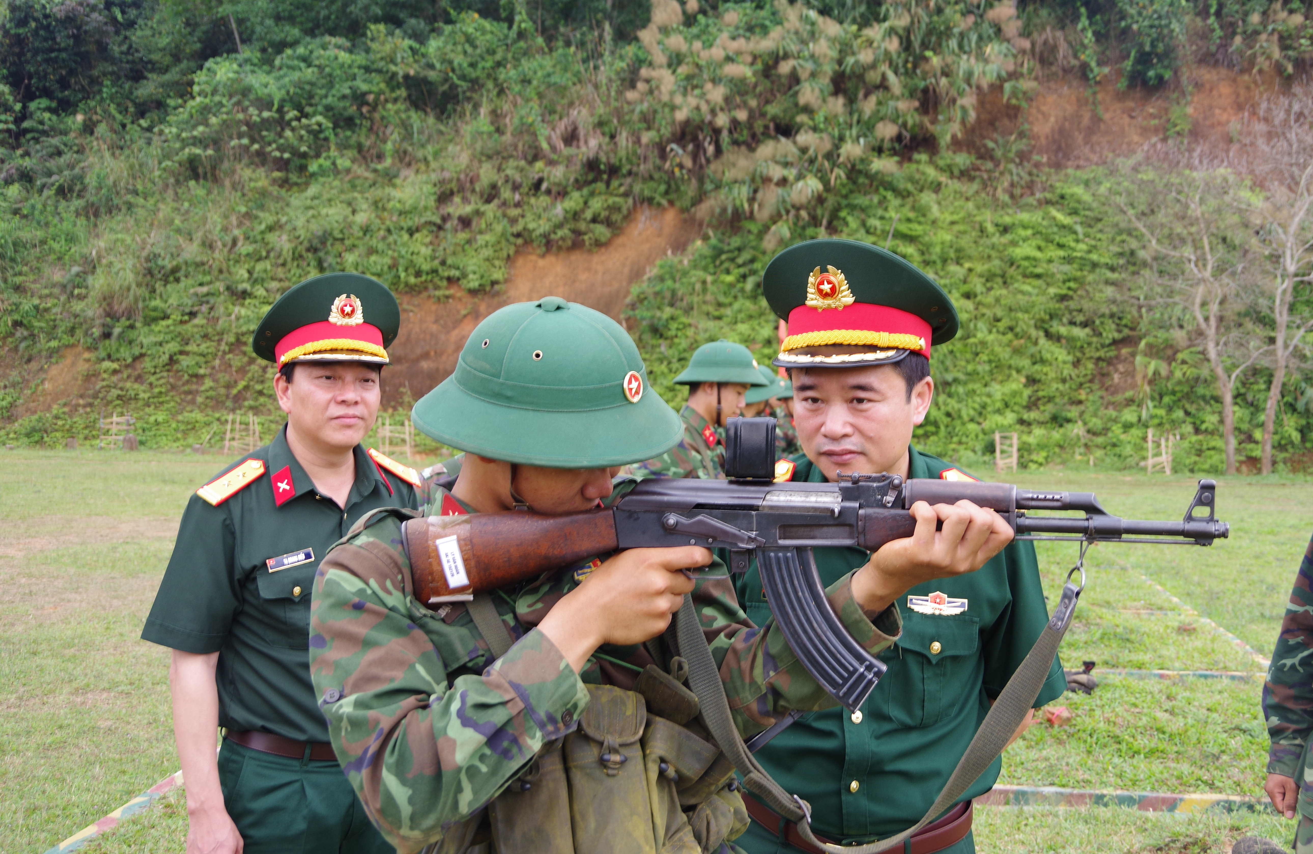 Thủ trưởng Bộ CHQS tỉnh kiểm tra đường ngắm súng tiểu liên AK đối với chiến sĩ mới. cu-6.jpg