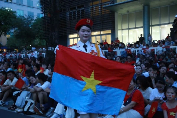 Nữ chiến sĩ xinh đẹp cầm lá cờ Giải phóng chụp ảnh lưu niệm trước giờ diễn tập.