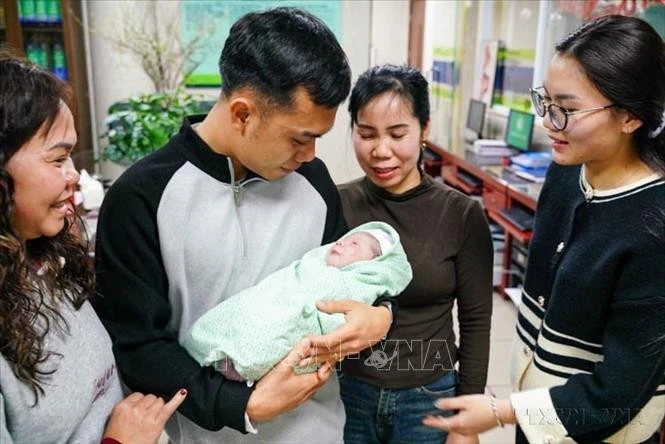 Gia đình vợ chồng anh Nguyễn Văn Hùng vui mừng đón con đầu lòng - "em bé rắn" đầu tiên của năm Ất Tỵ, tại Bệnh viện Phụ sản Hà Nội (2025). Ảnh: Khánh Hoà/TTXVN