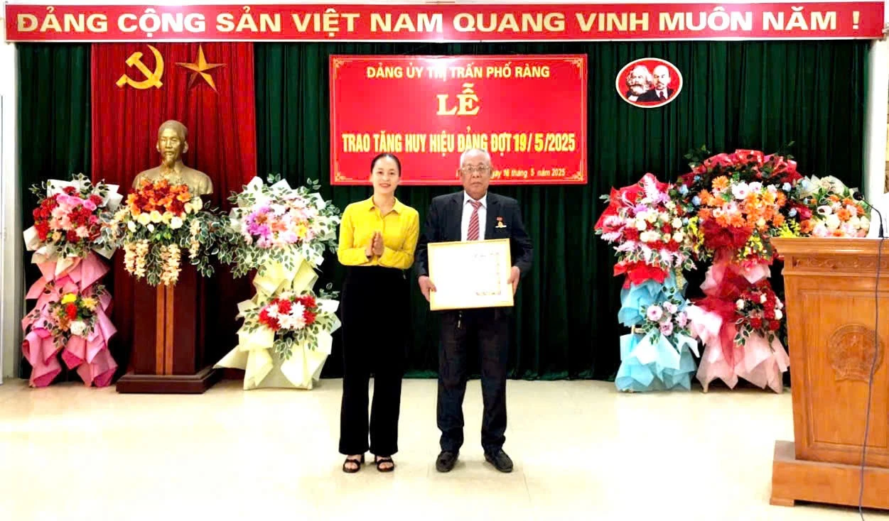 Lãnh đạo Đảng ủy thị trấn Phố Ràng trao Huy hiệu Đảng cho đảng viên 55 năm tuổi đảng.
