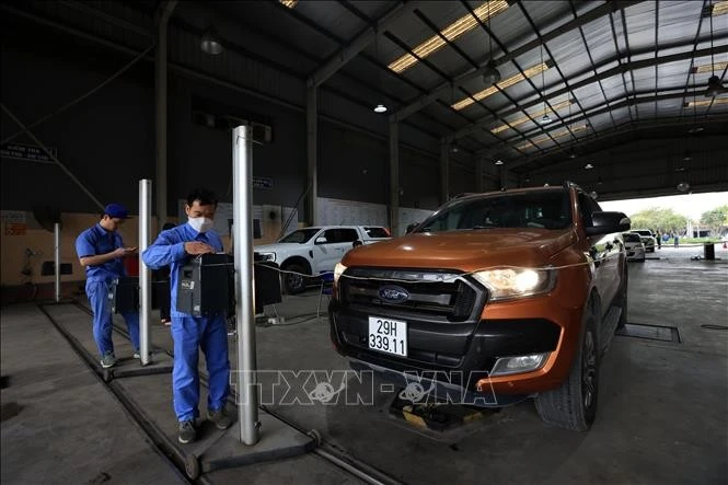 Đăng kiểm viên kiểm tra độ chiếu sáng của phương tiện đến đăng kiểm. Ảnh minh họa: Tuấn Anh/TTXVN