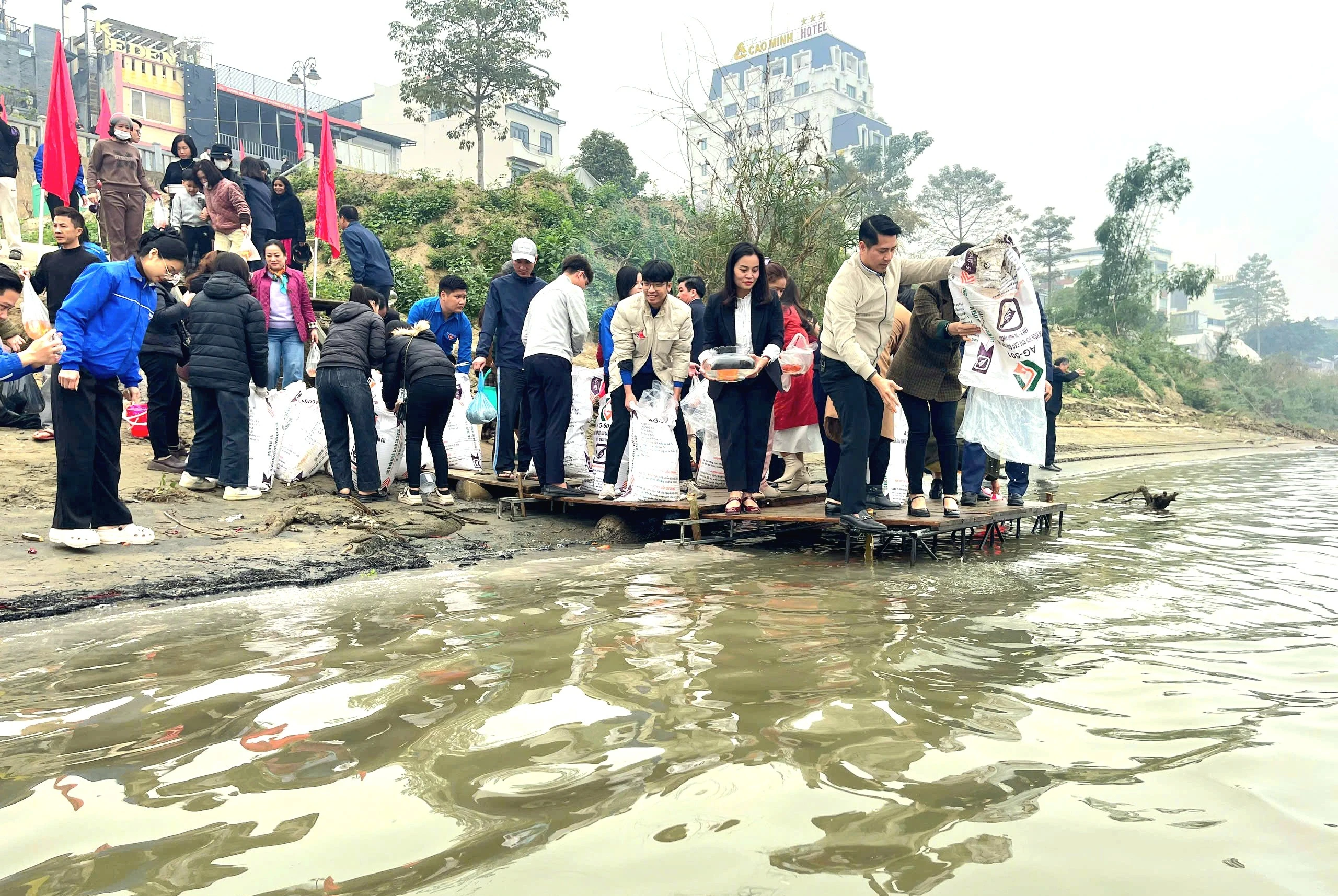 Người dân tham gia thả cá phóng sinh tại bờ kè sông Hồng.