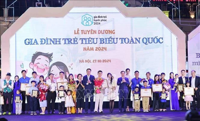 Đại biểu cùng các gia đình được tuyên dương tại chương trình. Ảnh: Minh Đức/TTXVN