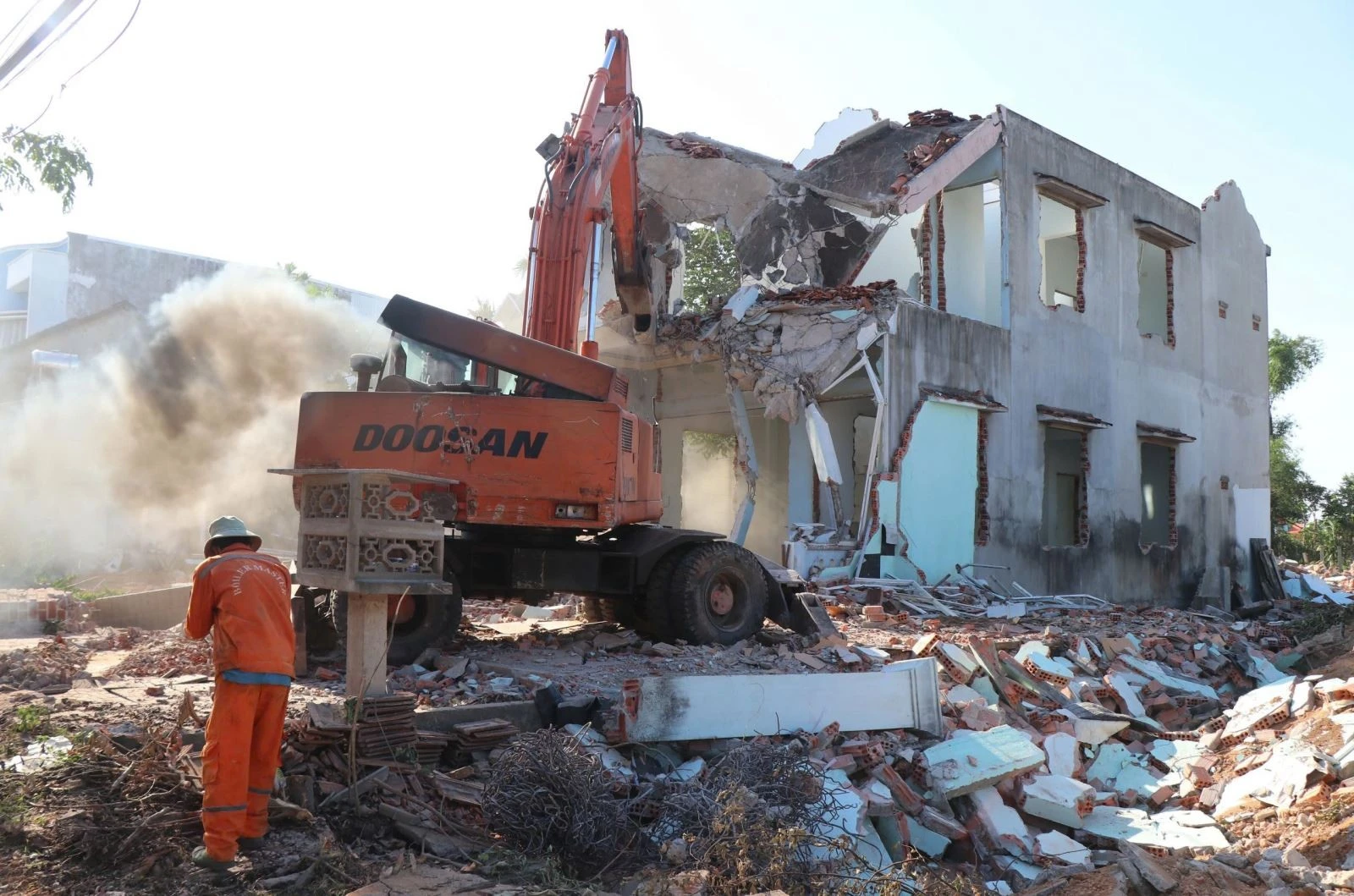 Lực lượng chức năng hỗ trợ người dân xã Nghĩa Kỳ (huyện Tư Nghĩa, Quảng Ngãi) tháo dỡ nhà ở, di dời tài sản để làm đường. Ảnh: Phạm Cường/TTXVN.