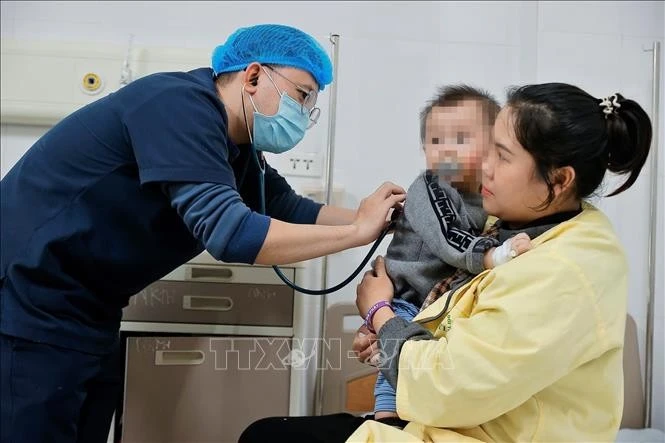 Bác sĩ thăm khám cho bệnh nhi mắc cúm A đang điều trị tại Khoa Nhi, Bệnh viện Bệnh nhiệt đới Trung ương. Ảnh: Minh Quyết/TTXVN