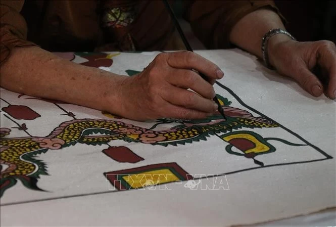 Vẽ hình tượng rồng trong tranh Đông Hồ. Ảnh: Thanh Thương/TTXVN