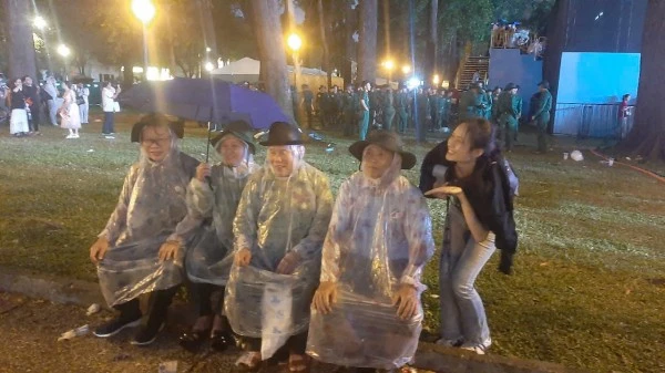 Người dân mặc áo mưa đợi xem diễu binh.