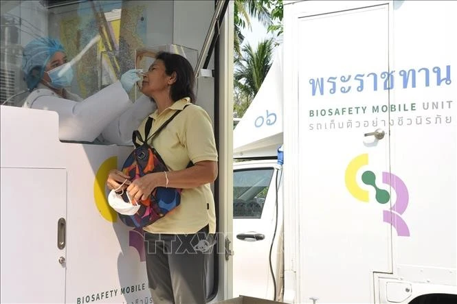 Nhân viên y tế lấy mẫu xét nghiệm COVID-19 cho người dân tại Bangkok, Thái Lan. Ảnh: THX/TTXVN