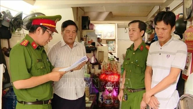 Lực lượng công an thực hiện thủ tục khởi tố bị can, ra lệnh bắt giam các đối tượng trong đường dây buôn bán vũ khí trên không gian mạng. Ảnh: TTXVN phát