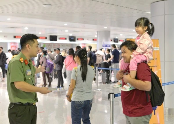 Cán bộ Công an cửa khẩu Cảng hàng không quốc tế Tân Sơn Nhất hướng dẫn người dân làm thủ tục xuất nhập cảnh.