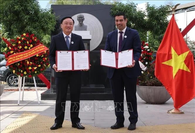 Đại diện huyện Nam Đàn (tỉnh Nghệ An) và quận Cerro Navia trao văn kiện hợp tác. Ảnh: Lâm Khánh/TTXVN