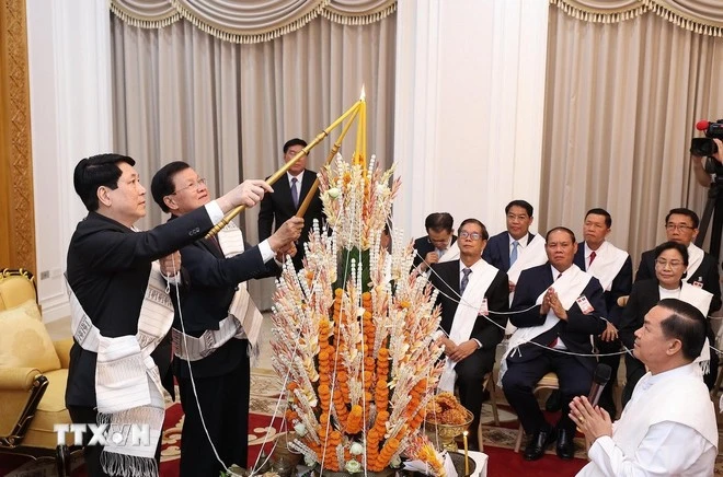 Chủ tịch nước Lương Cường cùng Tổng Bí thư, Chủ tịch nước Lào Thongloun Sisoulith dự lễ buộc chỉ cầu bình an, may mắn nhân dịp Tết Bunpimay của Lào. (Ảnh: Lâm Khánh/TTXVN)