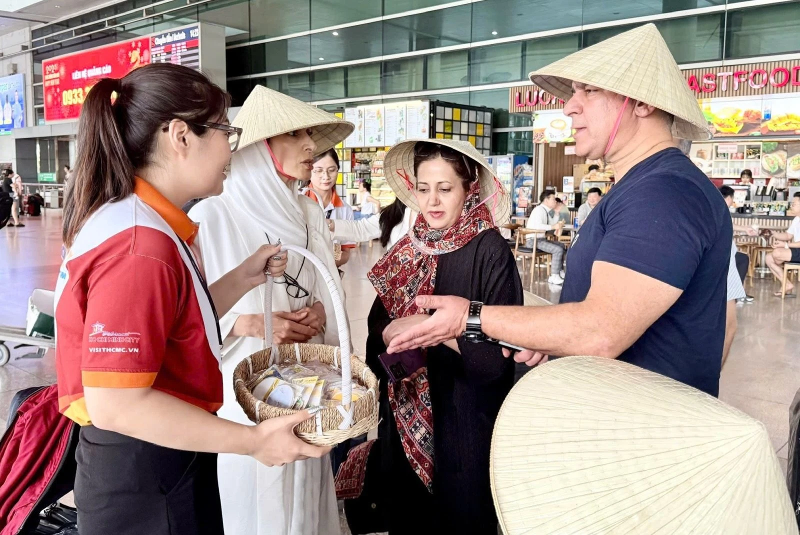 Du khách Iran được tặng nón lá, quà lưu niêm trước khi đi tham quan TP Hồ Chí Minh. Ảnh: Sở Du lịch TP Hồ Chí Minh cung cấp