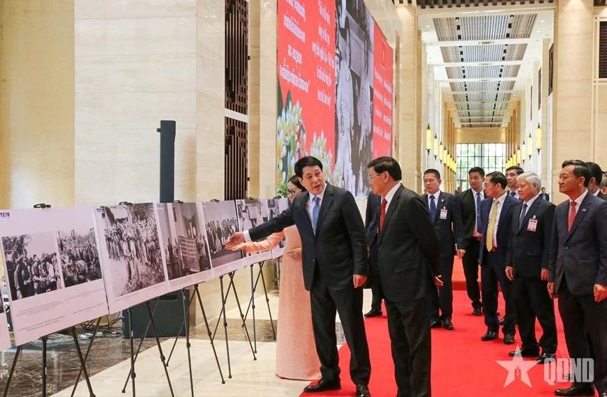Chủ tịch nước Lương Cường và Tổng Bí thư, Chủ tịch nước Lào Thongloun Sisoulith cùng các đại biểu xem triển lãm ảnh về quan hệ hai nước do Thông tấn xã Việt Nam thực hiện.