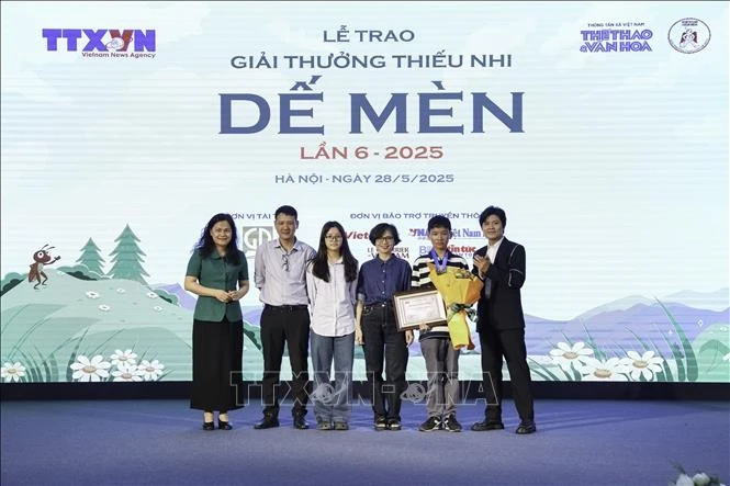Phó Tổng Giám đốc TTXVN Nguyễn Thị Sự và nhạc sĩ Nguyễn Văn Chung (Đại sứ truyền cảm hứng Dế Mèn) lên trao giải "Khát vọng Dế Mèn" thứ ba cho các tác giả. Ảnh: Lê Đông/TTXVN
