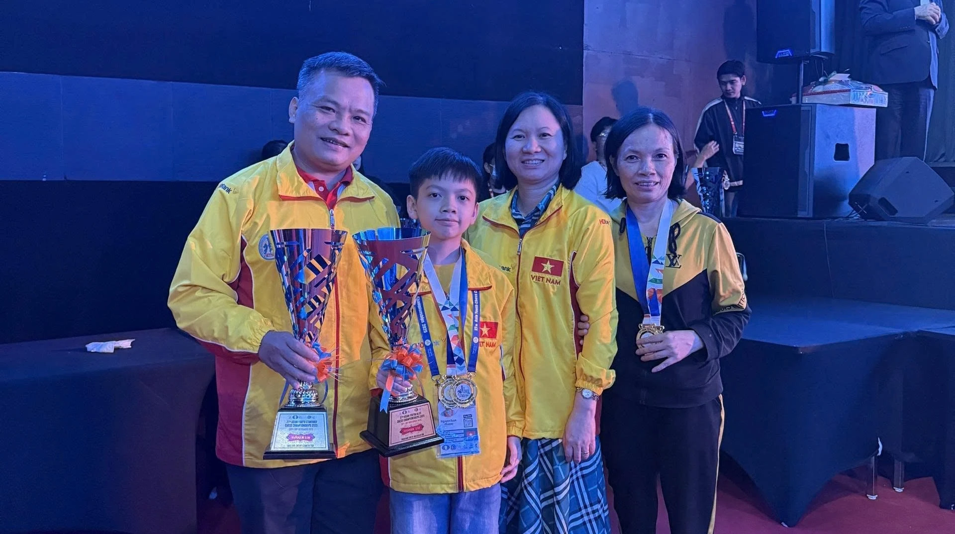 Kỳ thủ Xuân Phương (giữa) bên cạnh HLV Bùi Vinh và người thân.