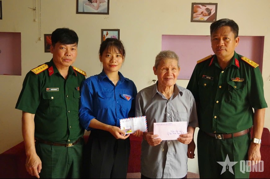 Thượng tá Lê Viết Xuân (ngoài cùng), Phó chính ủy Đoàn Kinh tế-Quốc phòng 345 trao quà của đơn vị tặng gia đình chính sách. 26-7-qk2.jpg