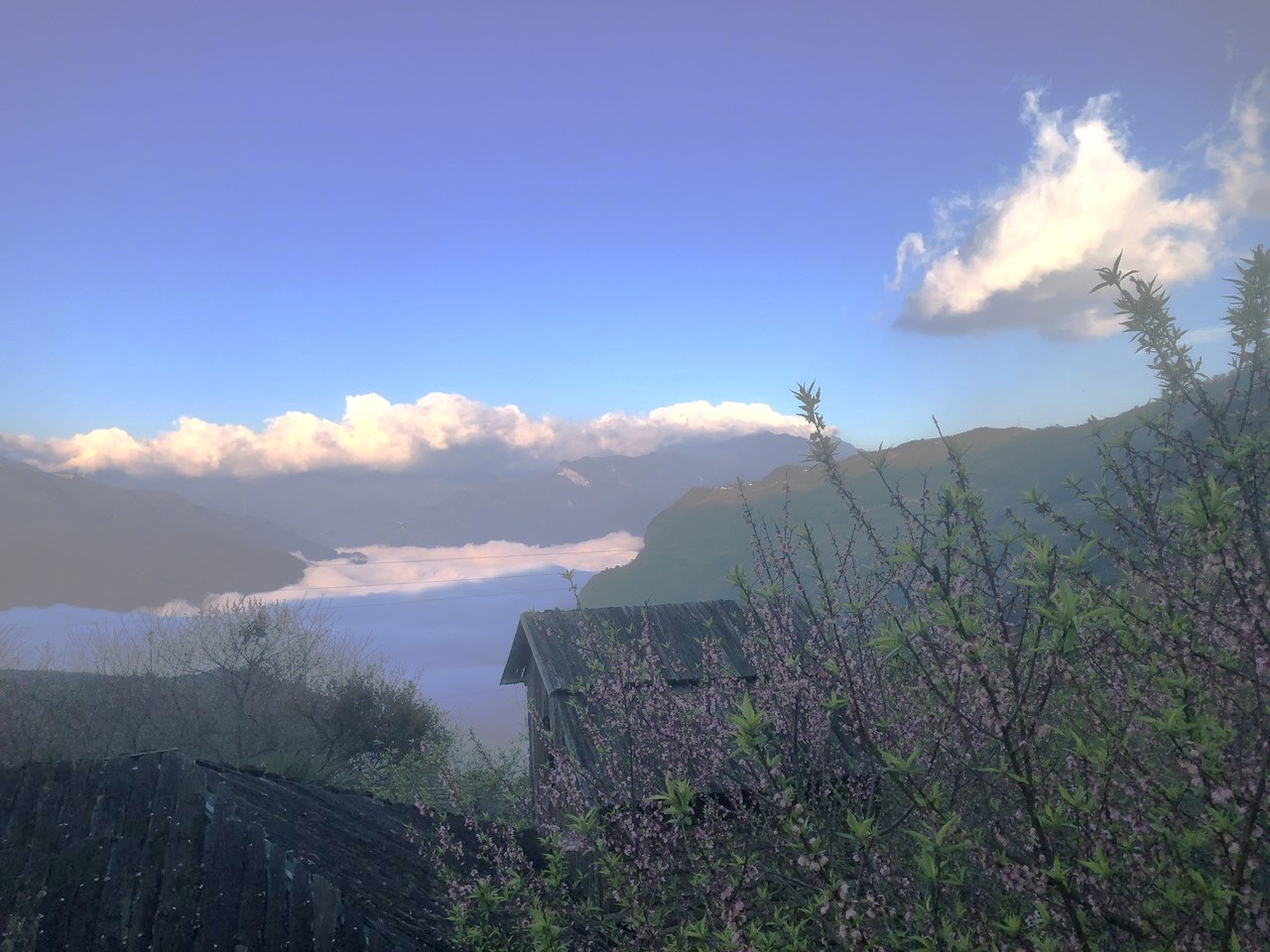 Trong sương sớm, ánh mặt trời xuyên qua từng áng mây trắng xóa, biển mây cuồn cuộn trôi, dâng lên như sóng biển lững lờ trôi giữa bầu trời.