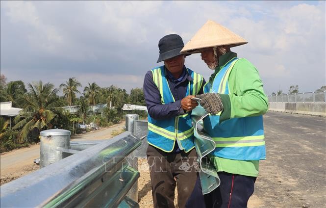 Công nhân thi công hạng mục an toàn giao thông trên cao tốc Cần Thơ - Cà Mau.