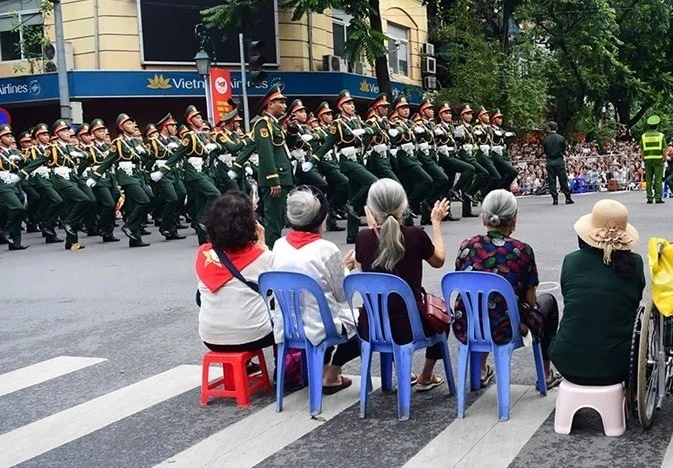 Người dân hai bên đường chào đón đoàn diễu binh.