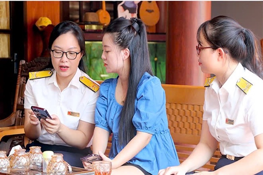 Cán bộ ngành thuế hướng dẫn hộ kinh doanh chuyển đổi mô hình từ thuế khoán sang kê khai. Ảnh: HUY HÙNG