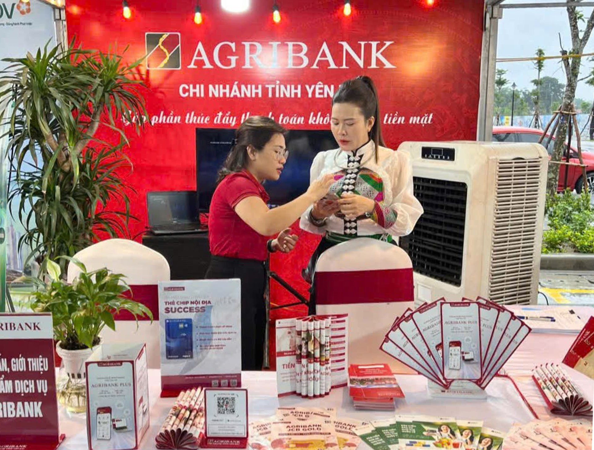 Nhân viên Ngân hàng Nông nghiệp và Phát triển nông thôn (Agribank) Chi nhánh Yên Bái hướng dẫn khách hàng sử dụng ứng dụng trên điện thoại di động. 15-9-anh3.jpg