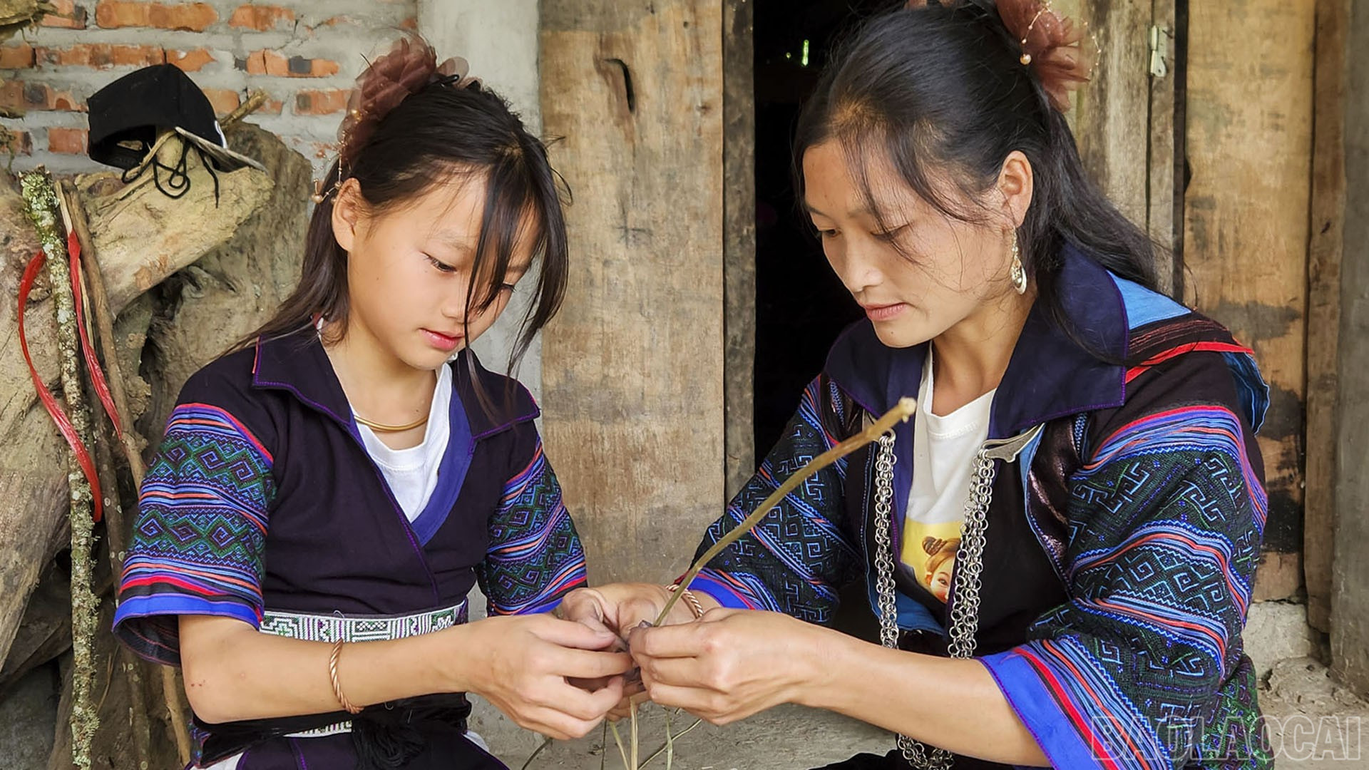 Phụ nữ Mông truyền dạy cho con em mình nghề thủ công truyền thống. baolaocai-br_det2.jpg