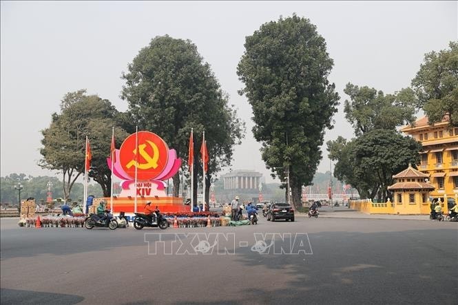 Biểu trưng Đại hội XIV với hình ảnh cờ đỏ, búa liềm vàng được đặt ở vị trí trung tâm, kết hợp cờ Đảng, cờ Tổ quốc và hoa trang trí.