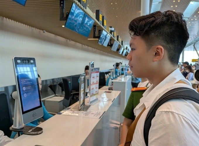 Khách làm thủ tục xác thực khuôn mặt tại ga T3 ngày 26/7.