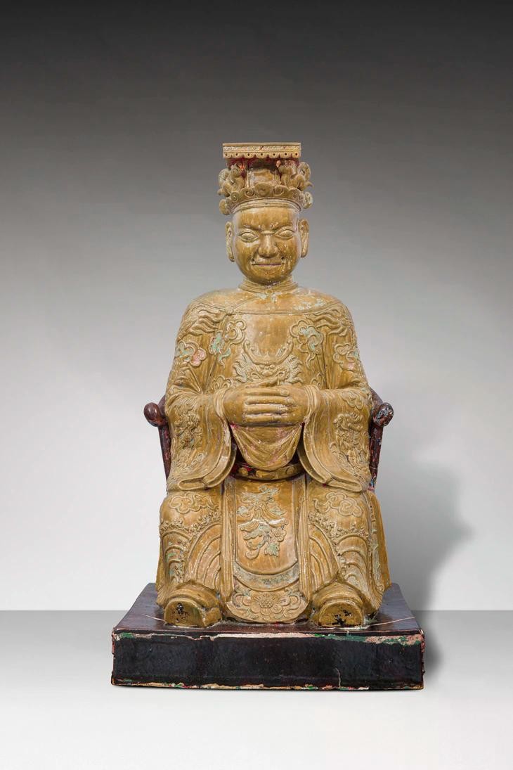 Tượng Địa quan Đại đế ngồi trên ngai. Đầu đội mũ bình thiên, đắp nổi “lưỡng long chầu ngọc”. Khuôn mặt tròn, mắt lồi, miệng hơi bặm lại, hai tai to, trên mặt tạo 5 lỗ để gắn râu. Thân mặc áo long bào lập lĩnh, hình rồng 4 móng và mây đắp nổi trên thân áo, rồng trước ngực nhìn chính diện, ống tay áo rộng, có đai, phần yếm đắp nổi dây hoa trái. Hai tay chắp trước ngực, bàn tay trái bên trong, bàn tay phải bên ngoài, chân mang hia. Lưng tượng cũng có lỗ vuông - nơi đặt những vật phẩm trong nghi lễ.