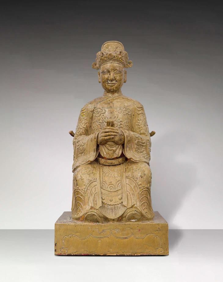 Tượng Thiên quan Đại đế trong tư thế ngồi trên ngai, đặt trên bệ hình chữ nhật. Đầu đội mũ phốc tròn đắp nổi “lưỡng long chầu ngọc”. Khuôn mặt phúc hậu, miệng hơi mỉm cười, hai tai to, trên mặt tạo 5 lỗ để gắn râu. Thân mặc áo long bào lập lĩnh, hình rồng 4 móng và mây đắp nổi trên thân áo, rồng trước ngực nhìn chính diện, ống tay áo rộng, có đai. Hai tay chắp trước ngực, bàn tay trái bên trong, bàn tay phải bên ngoài, hai ngón cái dựng đứng chạm vào nhau (nhất chỉ kình thiên), chân mang hia. Lưng tượng có lỗ vuông - nơi đặt những vật phẩm trong nghi lễ được gọi là “Yểm tâm tượng”.