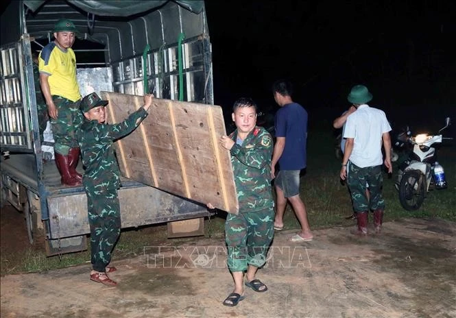 Cán bộ, chiến sĩ Ban chỉ huy phòng thủ khu vực 2 - Sông Mã vận chuyển vật dụng trong đêm 27/7 để dựng nhà bạt cho các hộ phải di dời khẩn cấp, tránh trú thiên tai, lũ ống, lũ quét.