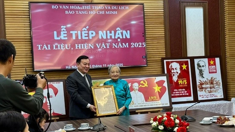 Đại diện gia đình nhạc sĩ Trần Hoàn trao tặng bản thảo nhạc và lời một số bài hát về Chủ tịch Hồ Chí Minh của nhạc sĩ Trần Hoàn.